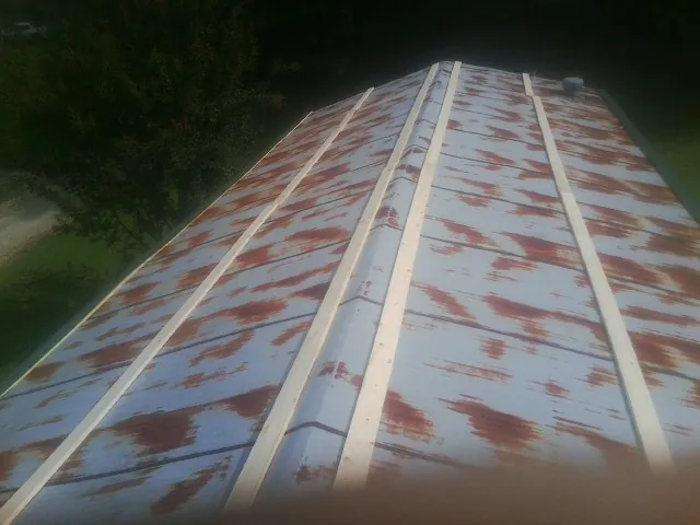 Rusted metal roof panels with new wood purlins before replacement — Storm Damage Roof Repair in Friedens by Roofing Brothers